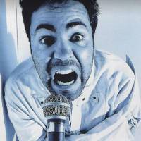 Vince Valenzuela in a black and white microphone yelling into a microphone. 
